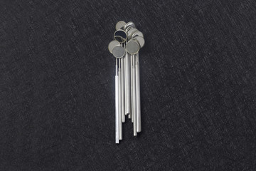 stack of dental mirrors on the center of dark background. Top view.