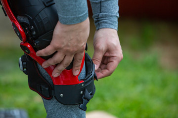 man puts protection on his knees forMotorsport