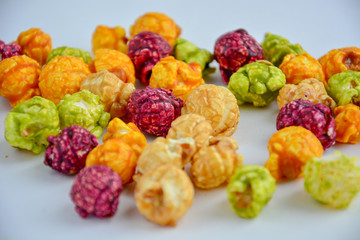 popcorn in caramel of different colors with fruit and berry flavors