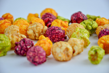 popcorn in caramel of different colors with fruit and berry flavors
