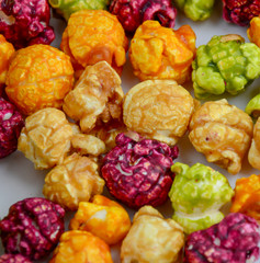 popcorn in caramel of different colors with fruit and berry flavors