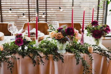 Coziness and style. Modern event design. Table setting at wedding reception. Floral compositions...