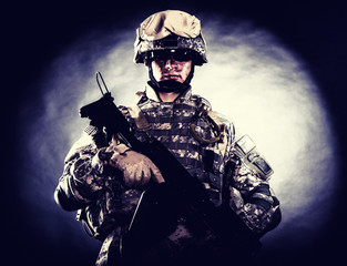 Low key studio portrait of private security service contractor, army infantry rifleman, US marine...