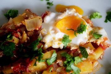 Afghan style breakfast with potatoes, tomatoes, onion, egg, parsley and spices.