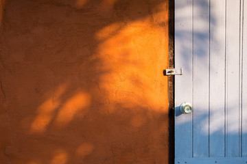 Wooden door of colorful country house with sunlight evening