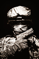 Special operations forces soldier in combat helmet with hidden behind balaclava and dark glasses...