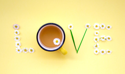 Love message written with flowers on yellow background. Individual Love concept.
