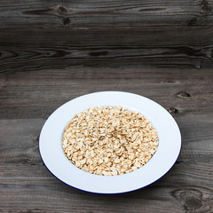 Oatmeal, rolled oats on rustic white wooden background.  Food Concept of healthy eating or vegan food. Healthy breakfast. Copyspace