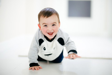 close up of funny baby boy crawling on carpet at home