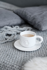 A cup of coffee  on a gray plaid