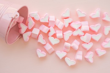 Fluffy pink heart marshmallow in small tank on pink background from top view