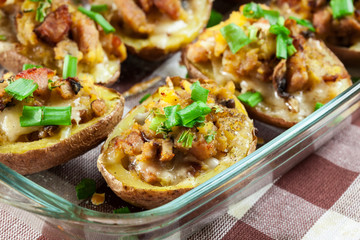 Baked potatoes in jacket stuffed with bacon, mushrooms and cheese. Dish served in baking dish..Baked potatoes stuffed with bacon, mushrooms and cheese
