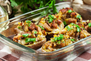 Baked potatoes in jacket stuffed with bacon, mushrooms and cheese. Dish served in baking dish..Baked potatoes stuffed with bacon, mushrooms and cheese