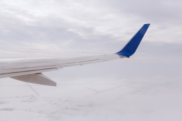 Fototapeta premium wing of aircraft flying above snowy land