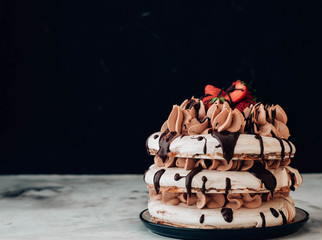 Pavlova cake with strawberries and chocolate icing. Toned image. Celebratory concept.