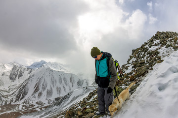 Fototapeta premium Man and dog labrador hike the cloudy mountains