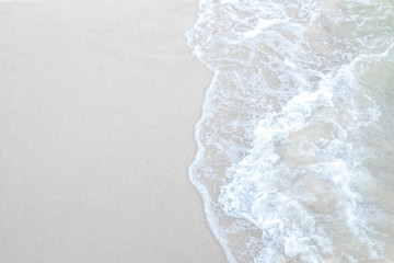 Fototapeta na wymiar White sand sea beach with water foam from sea wave.