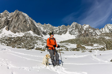 Man and dog labrador hike the cloudy mountains
