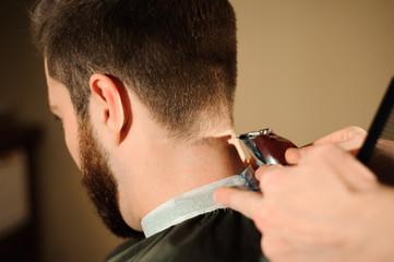 Master cuts hair and beard of men in the barbershop