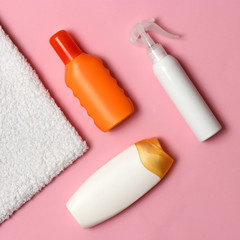 sunscreen, towel, hat, glasses on a colored background. Cosmetics for prevention of sunburn. top view, flatlay 