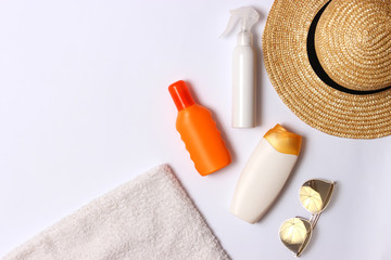 sunscreen, towel, hat, glasses on a white background. Cosmetics for safe sunburn. top view, flatlay