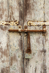Old door with rusted bolt and peeled paint at Spinola bay, St. Julian's, Malta, detail