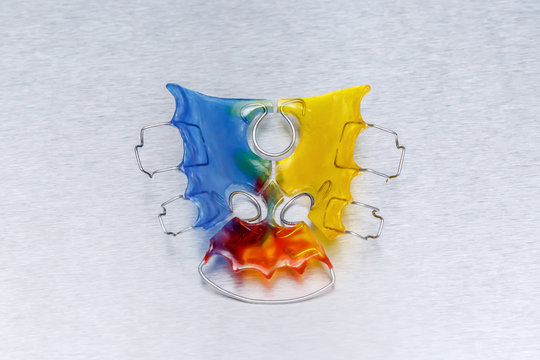Colorful dental braces or retainer for teeth on metall background