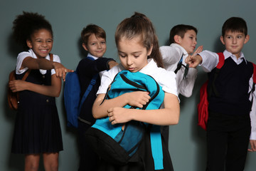 Children bullying their classmate on color background