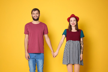 Obraz premium Trendy hipster couple posing together against color background