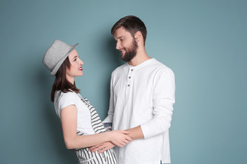 Trendy hipster couple posing together against color background