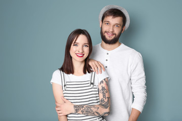 Naklejka premium Trendy hipster couple posing together against color background