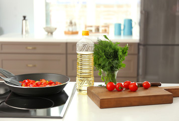 Bottle with cooking oil and ingredients on table