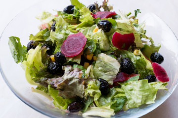 Beet Salad with Lettuce, Olive and Corn in Glass Bowl.