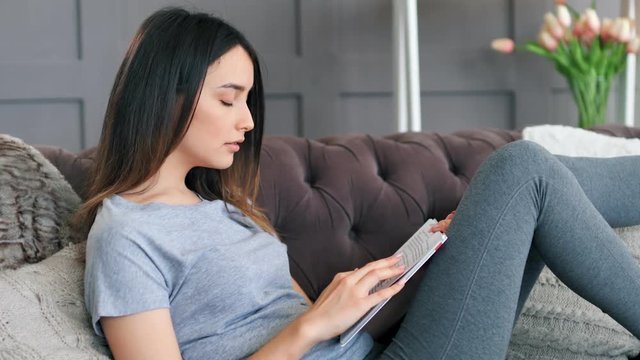 Young woman using digital tablet on sofa