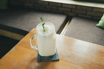 coconut water frappe with rosemary leaf on restaurant table