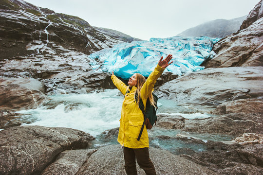 Happy Woman tourist traveling sightseeing Nigardsbreen glacier in Norway healthy Lifestyle adventure active vacations outdoor exploring Norway