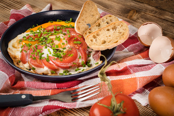 Homemade breakfast fried egg with tomato.
