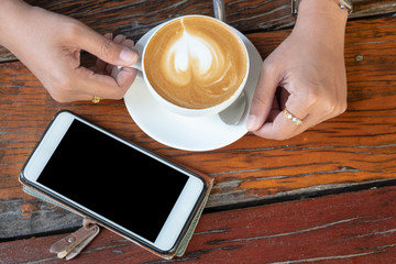 Fototapeta na wymiar latte coffee on wood and a smart phone