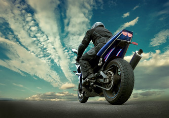Man seat on the motorcycle under sky with clouds © Andrii IURLOV