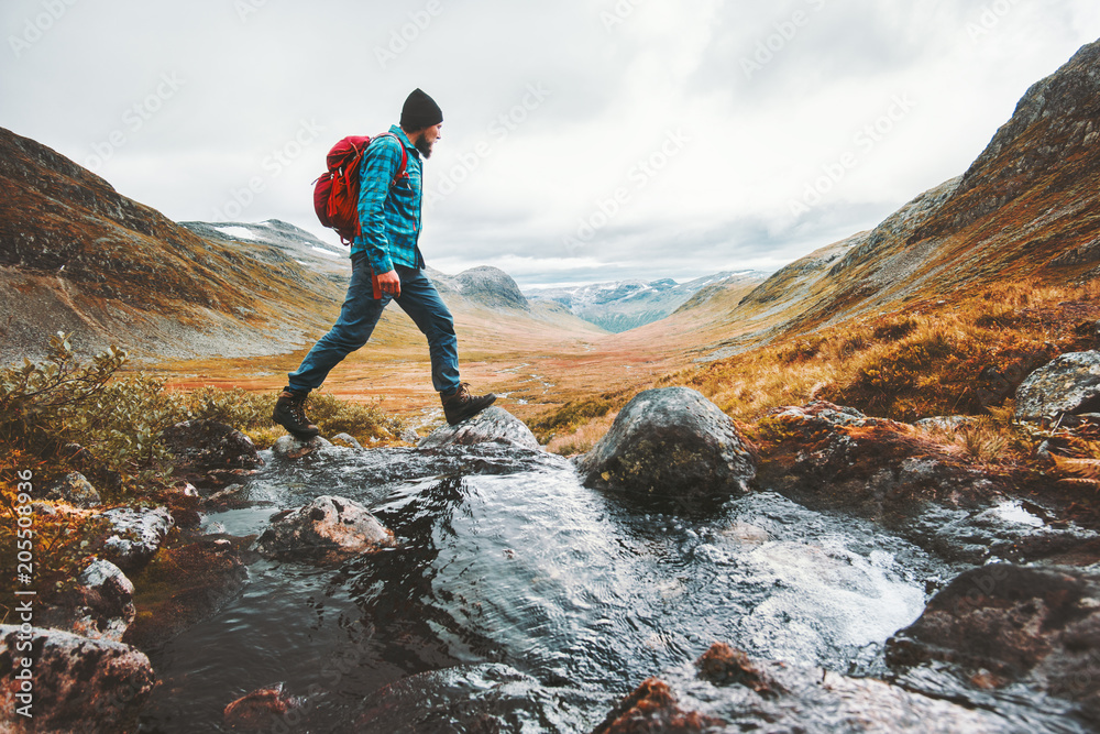 Wall mural man solo traveling backpacker hiking in scandinavian mountains active healthy lifestyle adventure jo