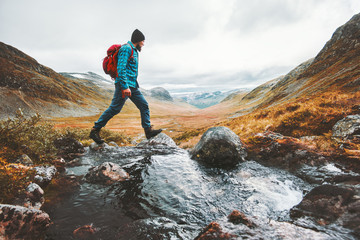Man solo traveling backpacker hiking in scandinavian mountains active healthy lifestyle adventure journey vacations - obrazy, fototapety, plakaty