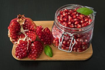 Ripe pomegranate fruit in a jar on wooden vintage background