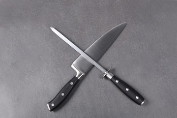 cook knife and sharpener on a slate board.