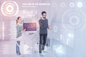 Clever colleagues. Smart experienced programmers standing in their modern office and using virtual reality in their work