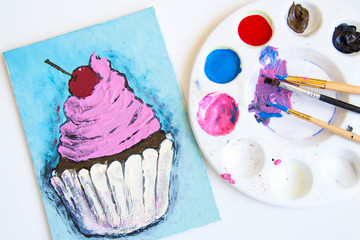 small canvas painting with paints beside it