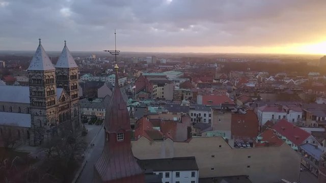 Drone shot flying over Lund city at sunset. Cathedral church building in the background