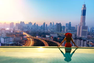 Zelfklevend Fotobehang woman enjoy city light in background in swimming pool on rooftop of building © tonjung