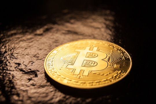 bitcoin coin on dark rock surface