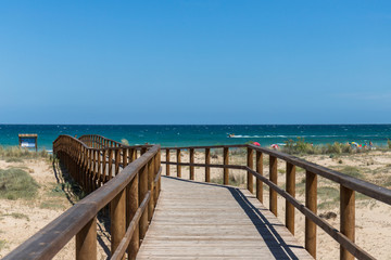 Obraz premium Wooden bridge landscape at the beach ending in turquoise blue sea
