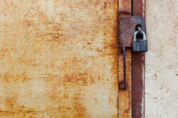 scary old iron door closed on a padlock, left a large rusty door texture